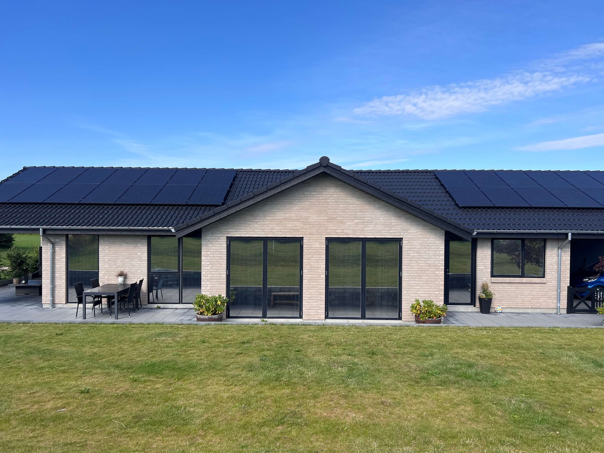 Moderne bungalow med solceller og store vinduer med solfilm monteret af Nordic Solfilm